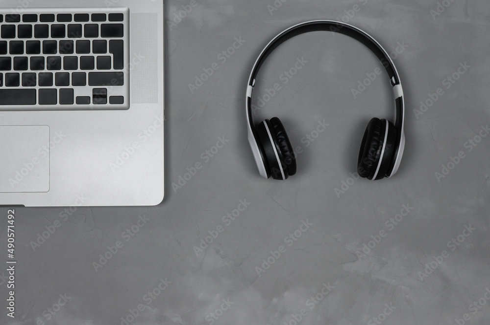 Layout of a laptop with stereo headphones on a gray background. Layout of a laptop with stereo headphones on a gray background.