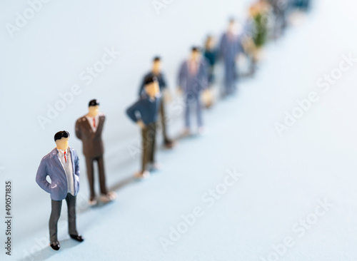 some miniature people lined up on a colored surface	