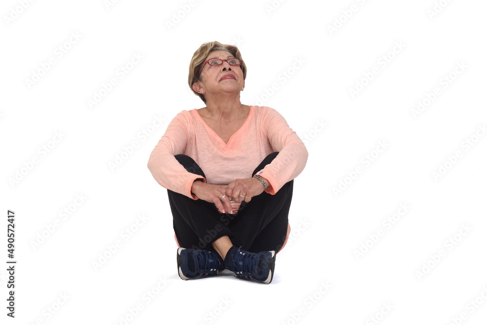 front view of senior woman sitting on the floor look up on white background front view of senior woman sitting on the floor look up on white background