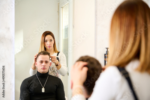 Hairdresser cutting hair and styling a client in the barbershop