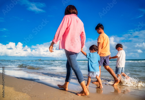 Asian family vacation holiday on the beach in the sunset