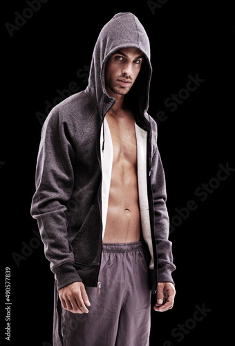 Brooding manliness. Studio shot of a brooding bare-chested young man wearing a hoodie.