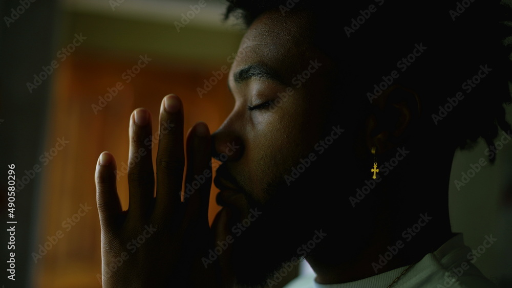 A religious black man praying to God with seeking divine help A religious black man praying to God with seeking divine help