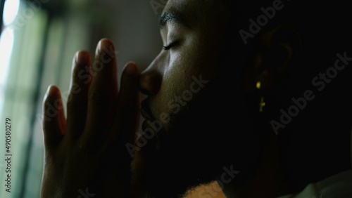 A religious black man praying to God with seeking divine help