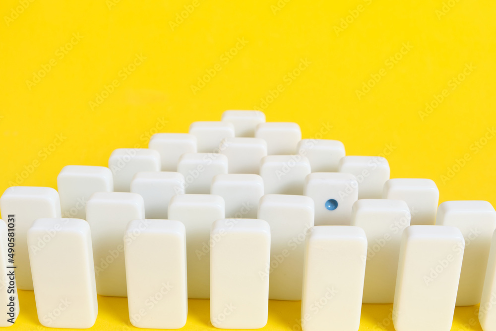 Obraz premium Rows white domino chips with one eye catching, concept is individual and not like everyone else.
