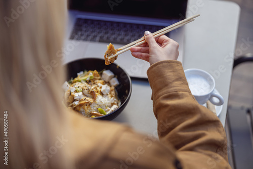 Close-up of woman hands holding food with chopsticks