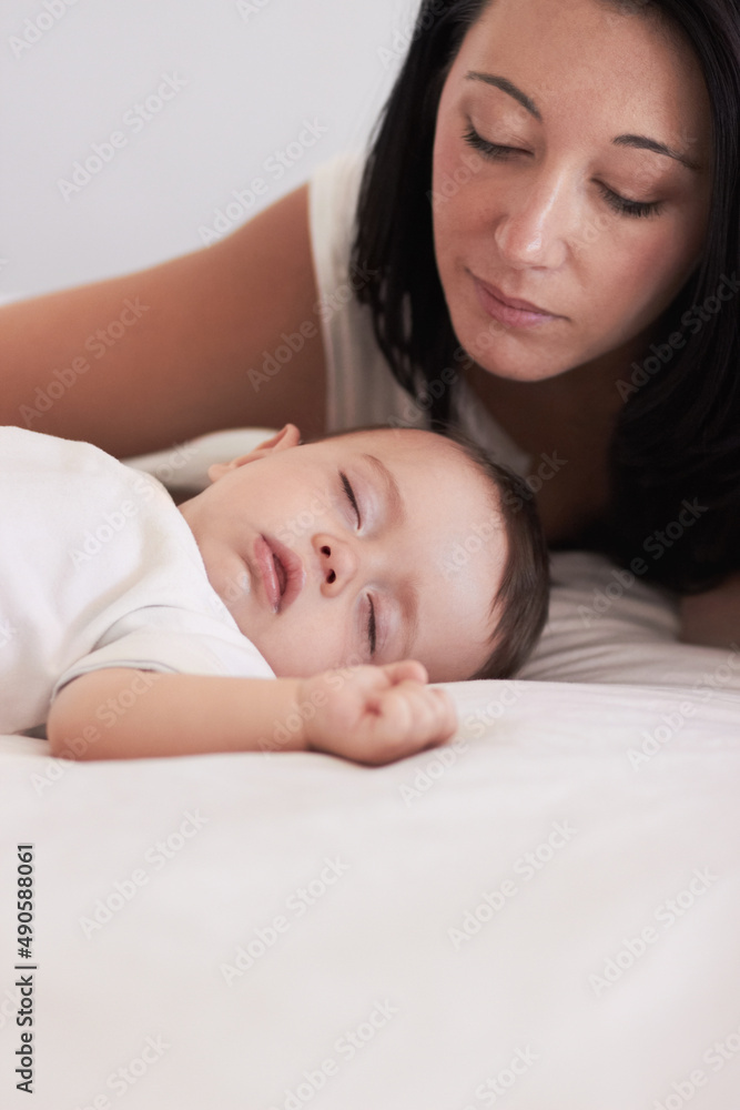 Hes so peaceful. A mother looking lovingly at her baby boy while he sleeps. Hes so peaceful. A mother looking lovingly at her baby boy while he sleeps.