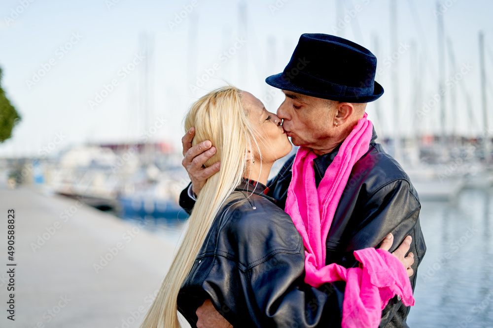 Romantic middle-aged couple kissing in the harbor Romantic middle-aged couple kissing in the harbor