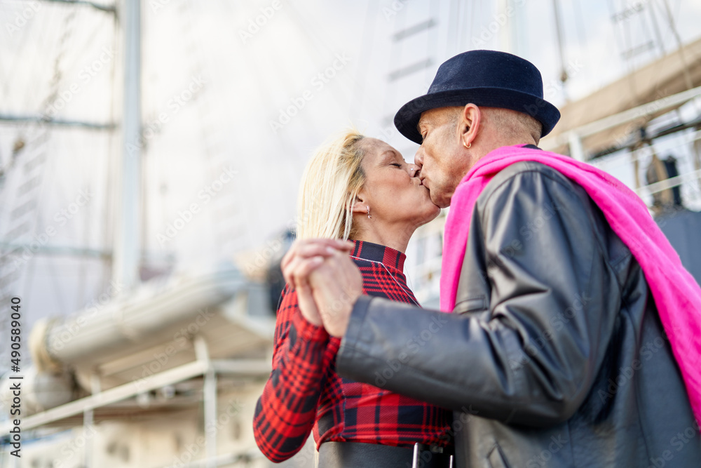 Romantic middle-aged couple kissing in the marina Romantic middle-aged couple kissing in the marina
