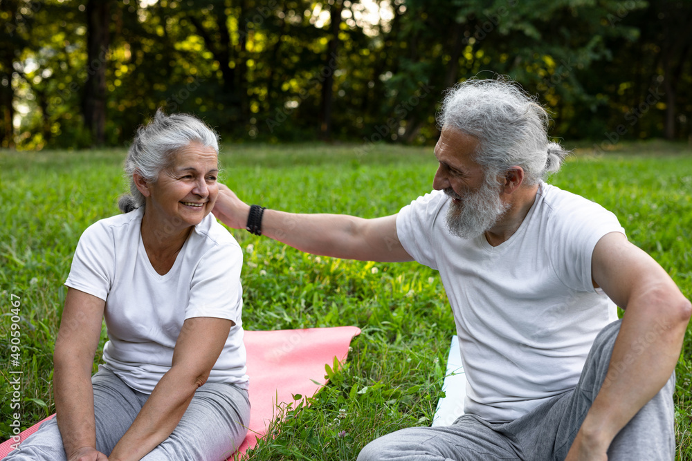 Obraz premium Beautiful senior couple is practicing yoga in the nature