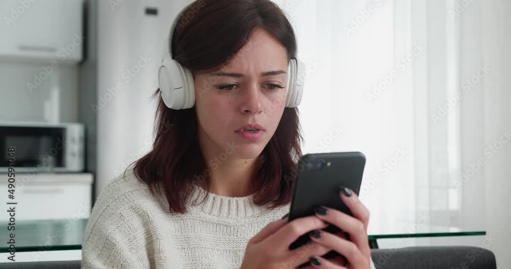 Disgust on face, young woman looking at camera on smartphone Disgust on face, young woman looking at camera on smartphone