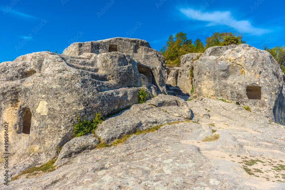 Ancient stone caves in a town-fortess Eski-Kermen high in a rocky mountains, Crimea.