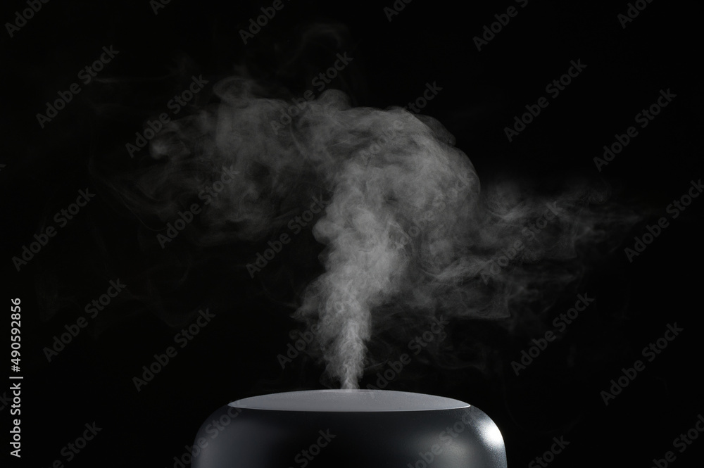 The concept of humidification of the air. Photo with copy space. Modern air humidifier on black background. - obrazy, fototapety, plakaty 