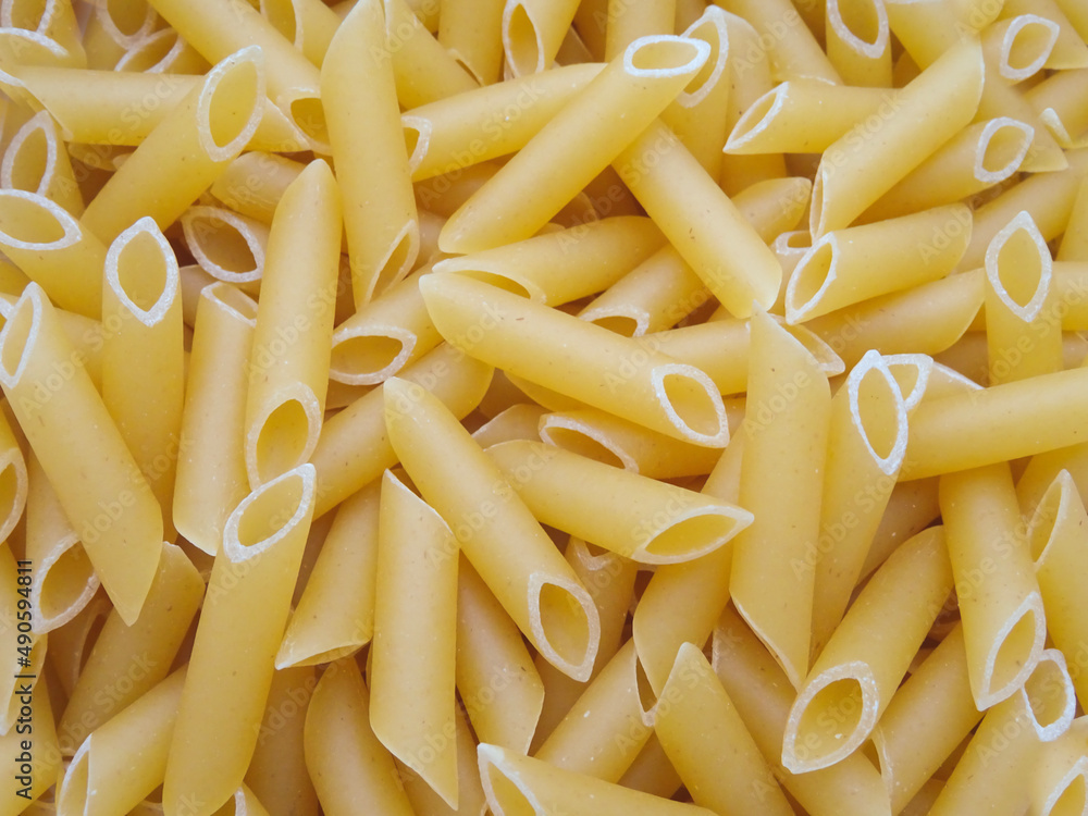 Close-up background of dry penne pasta macaroni. View from above. Close-up background of dry penne pasta macaroni. View from above.
