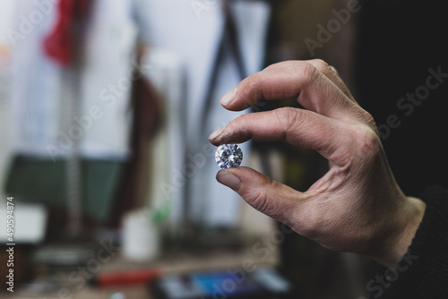 a hand holding a shiny diamond