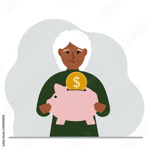 Sad old woman holds a piggy bank, a coin falls into the piggy bank. The concept of saving finance, savings, investing finances.
