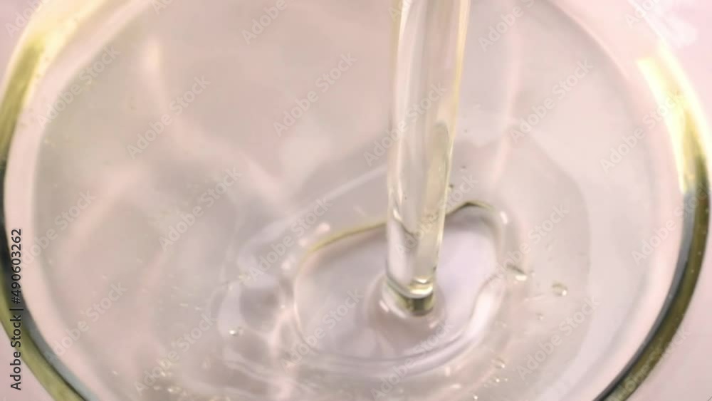 Vegetable sunflower or olive oil poured into glass bowl on black background. Health benefits of oil consumption concept. Slow motion Vegetable sunflower or olive oil poured into glass bowl on black background. Health benefits of oil consumption concept. Slow motion