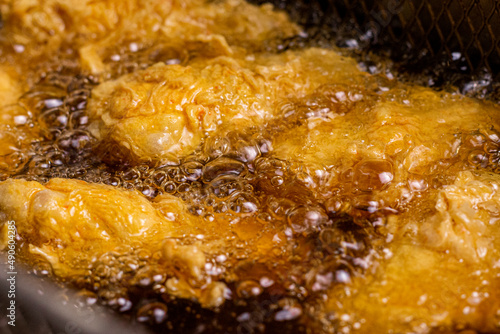 Crispy chicken Nuggets in boiling hot oil. Making crispy in the fryer hot oil. Fast food concept.