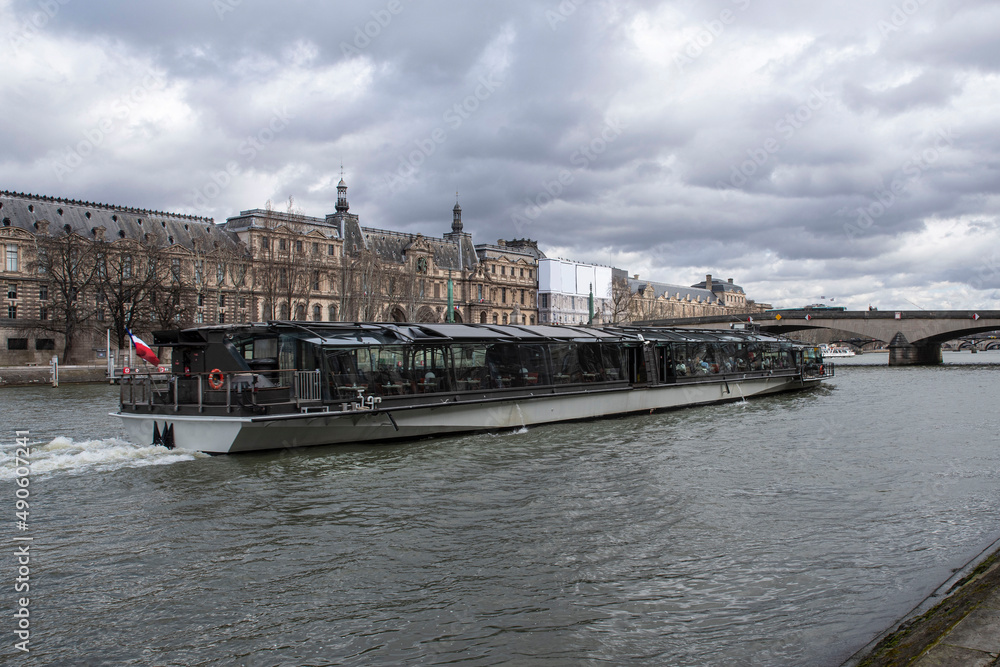 A boat on the Seine in Paris, France, with the Louvre behind it