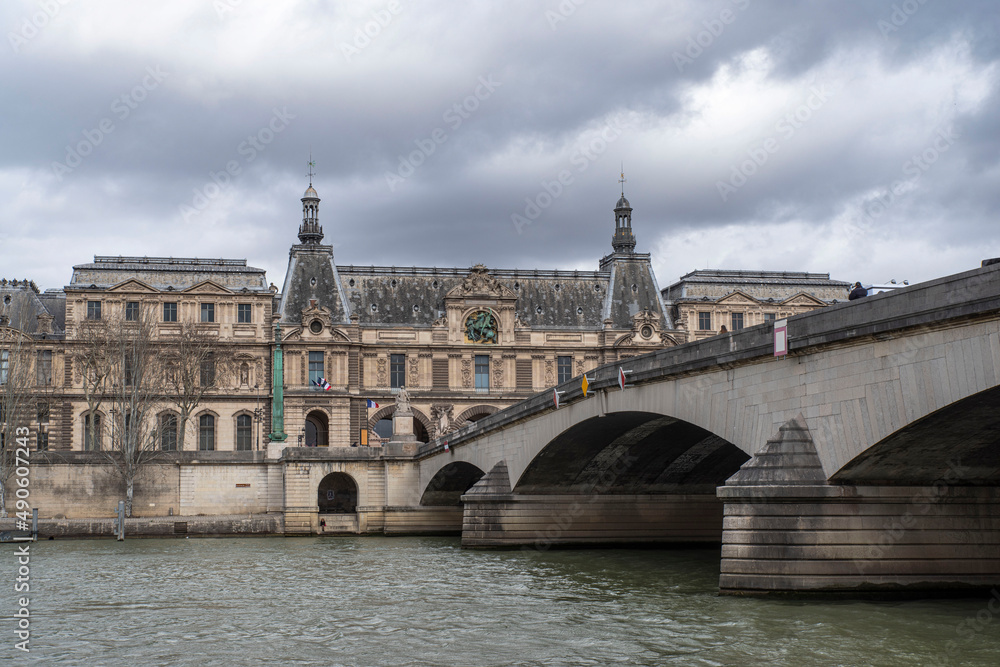 The Seine under a bridge in Paris, France, with the Louvre in the distance