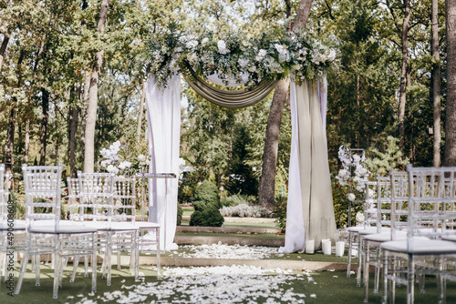 Elegant Wedding arch with fabric and flowers outdoors