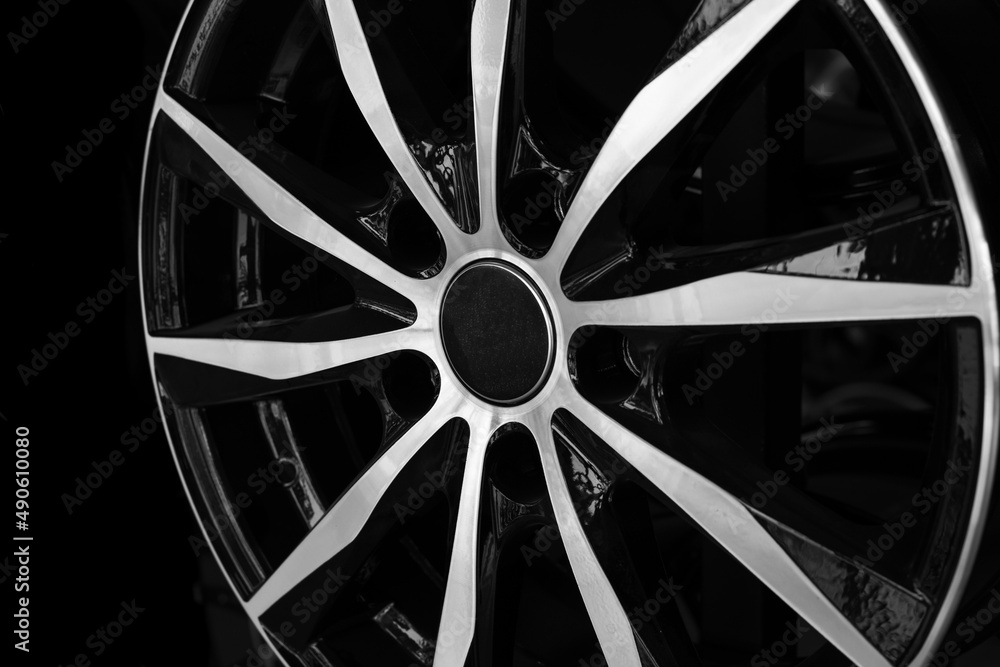 Automotive alloy wheel close-up on a black background. Showcase template