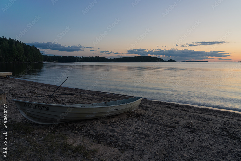 Seascape and a boat on the shore. Peaceful, calm, evening sky and sea. Natural background. Summer evening.