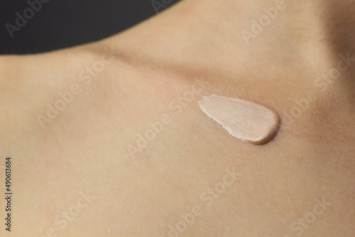 Obraz na płótnie Closeup of a woman applying highlighting lotion to her neck and chest. w salonie
