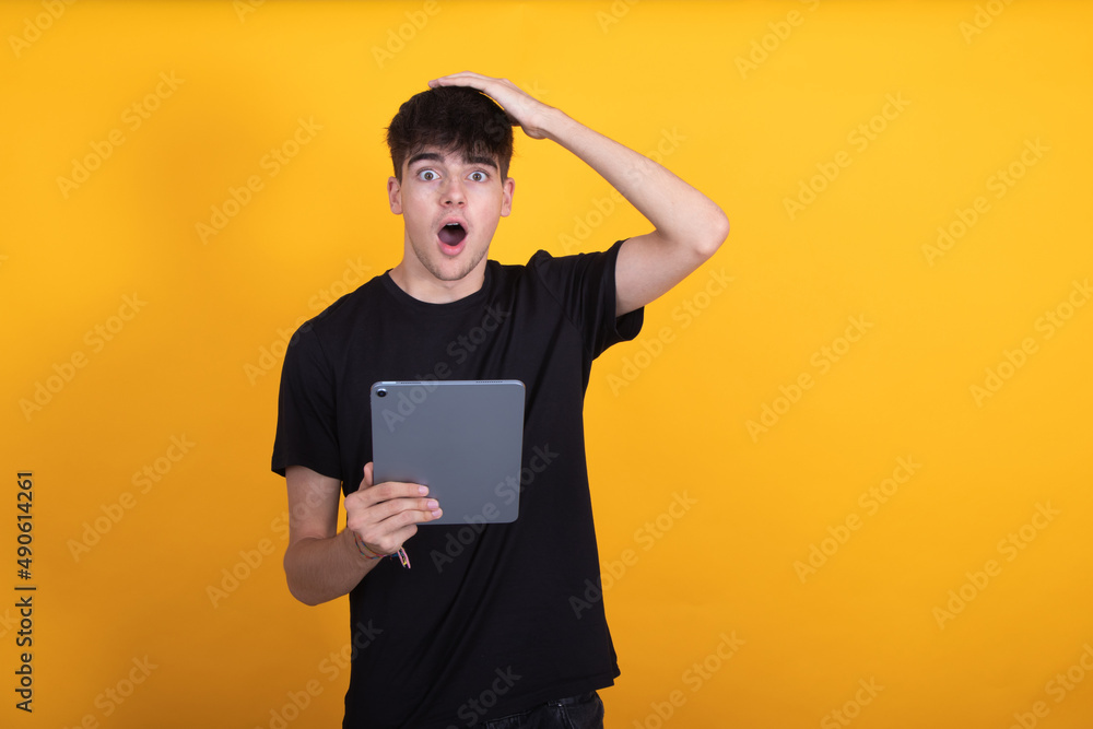 teen student with tablet isolated on background surprised