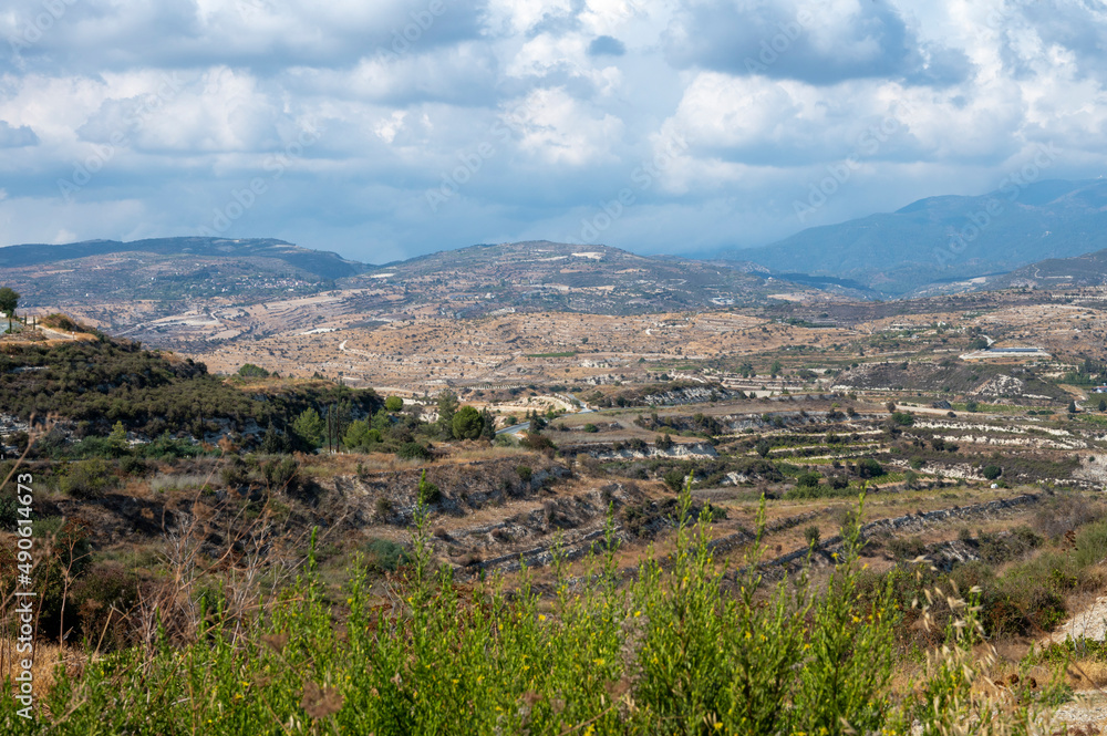 Aerial view on Troodos mountains, fertile valley with vineyards and olive groves and white roads, Cyprus