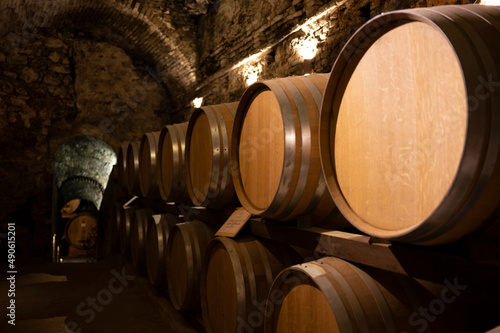 Medieval underground wine cellars with old red wine barrels for aging of vino nobile di Montepulciano in old town Montepulciano in Tuscany, Italy © barmalini