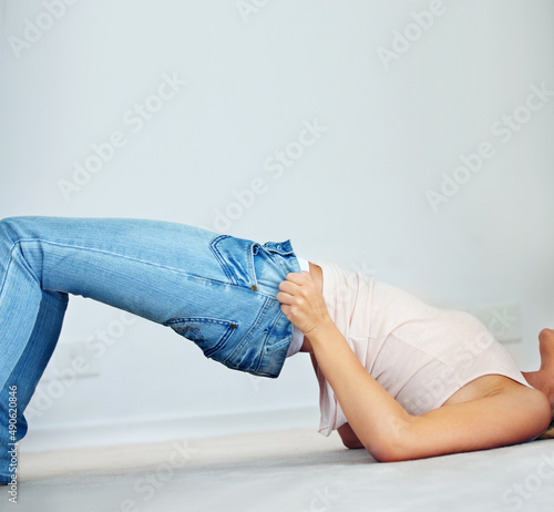 This is going to be a squeeze.... Cropped image of a woman trying to squeeze into a pair of jeans.