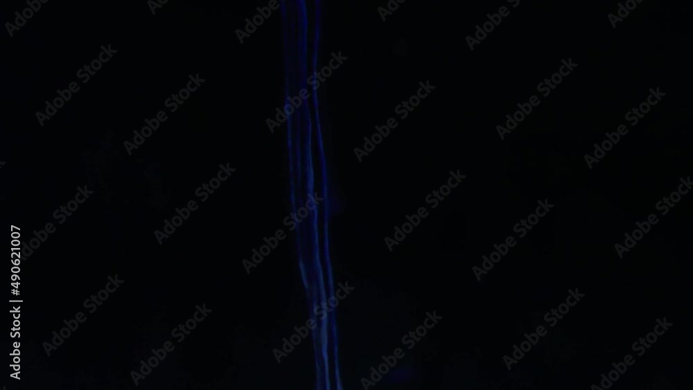blue ink color flowing from top to bottom in three laminar streams - dark black background - abstract - fluid blue ink color flowing from top to bottom in three laminar streams - dark black background - abstract - fluid