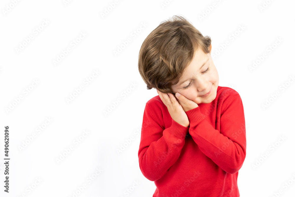 Tired kid with closed eyes leaning on palms as pillow pretending sleeping being exhausted seeing dreams standing against white background. Tired kid with closed eyes leaning on palms as pillow pretending sleeping being exhausted seeing dreams standing against white background.