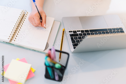 Hand of a young woman writing in a notebook 