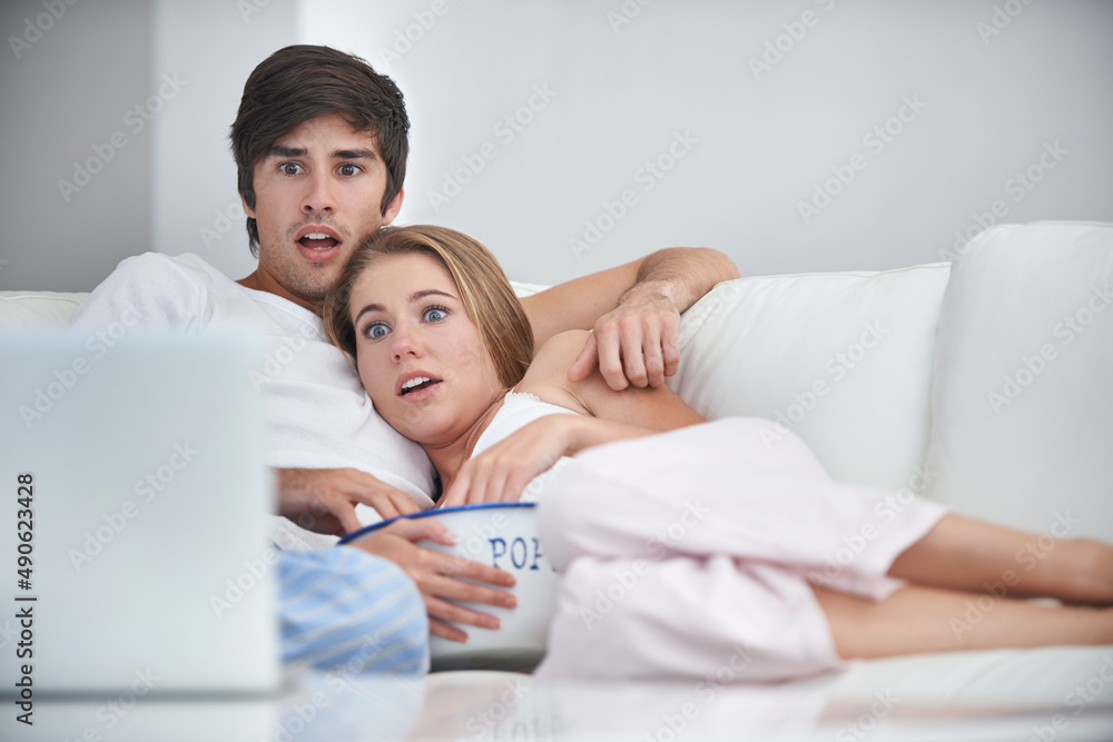 This is too tense. Shot of a young couple watching a scary movie at home. This is too tense. Shot of a young couple watching a scary movie at home.