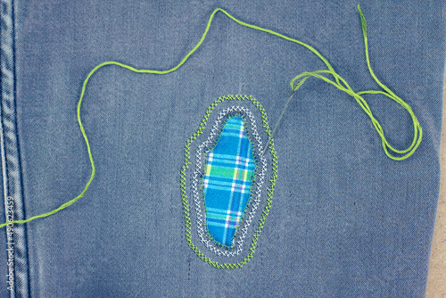 Visible mending on jeans, creative sustainable fashion, repair, mend and recycle. slow fashion make it last.