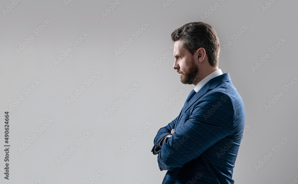 Hes a serious man. Serious businessman sideway grey background. Confident director keep arms crossed Hes a serious man. Serious businessman sideway grey background. Confident director keep arms crossed