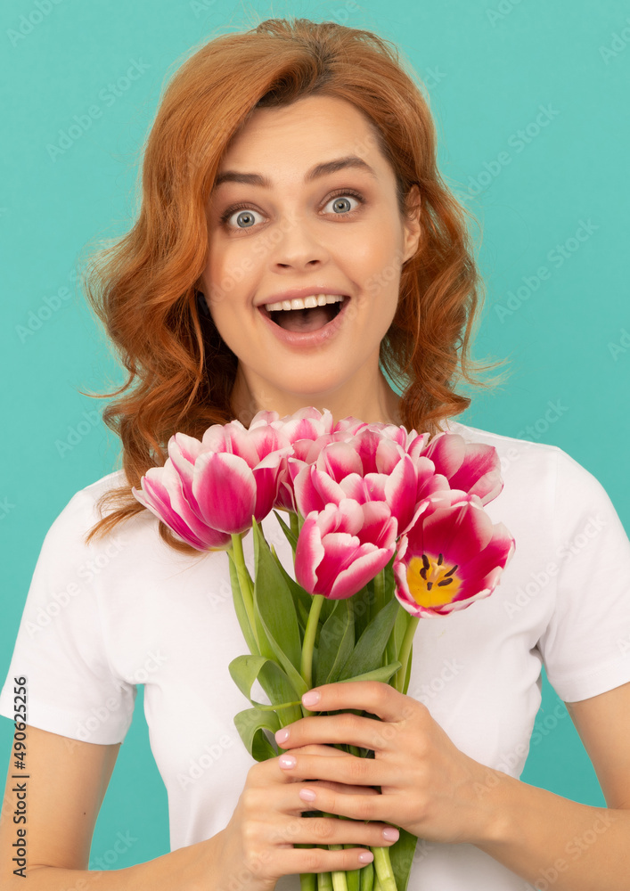 surprised girl with tulip flower bouquet on blue background surprised girl with tulip flower bouquet on blue background