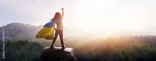 Fotografia girl with a cape of the flag of ukraine - concept of peace and freedom