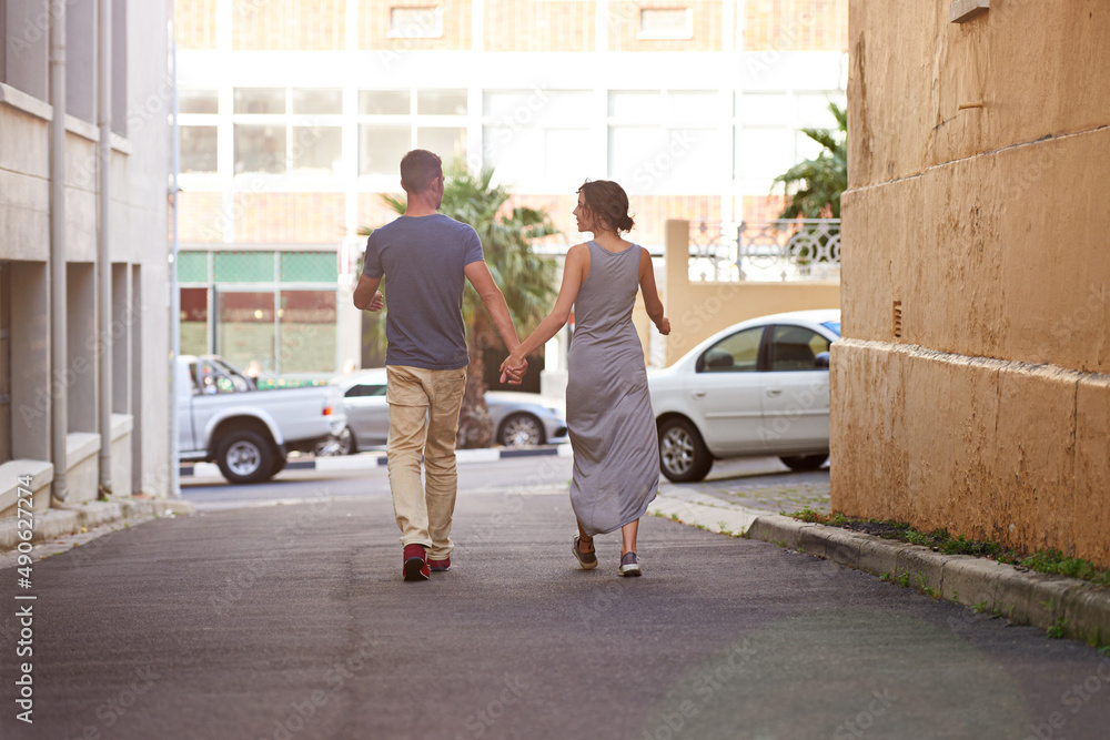 Urban loving. Shot of a young couple taking a walk outdoors. Urban loving. Shot of a young couple taking a walk outdoors.