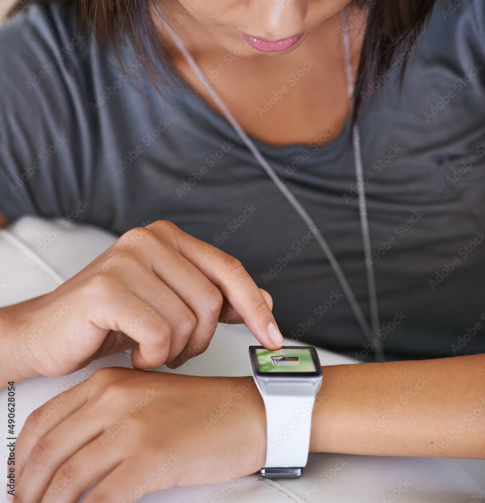 The technology of time. Cropped shot of a young woman looking at her smartwatch. The technology of time. Cropped shot of a young woman looking at her smartwatch.