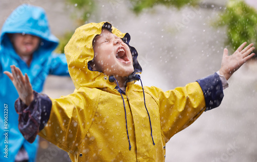 They love the rain. Shot of a young brother and sister playing in the rain. photo