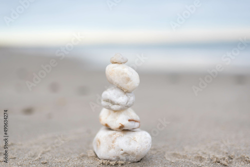 Canvas Print white zen stones stacked on a calm beach