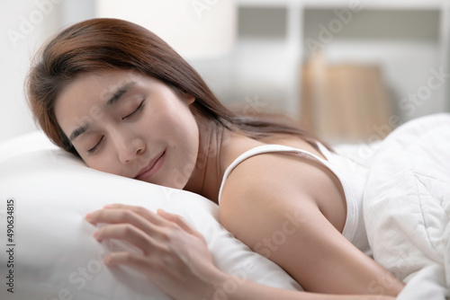 Young beautiful woman sleeping in her bed and relaxing in the morning photo