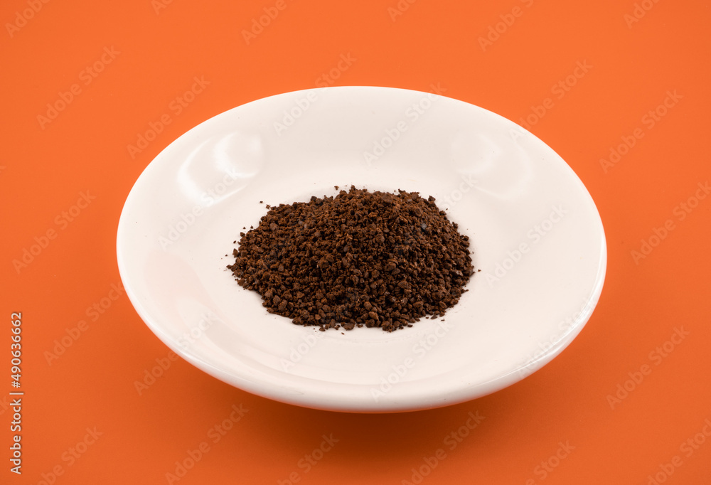 coffee grounds on plate with orange background coffee grounds on plate with orange background