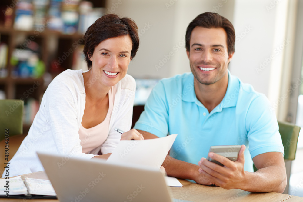 Were right on track with our budget. Portrait of a married couple working on their budget at home. Were right on track with our budget. Portrait of a married couple working on their budget at home.