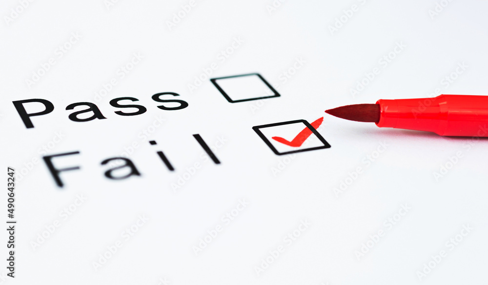 Tick boxes for Pass or Fail on paper with pen Tick boxes for Pass or Fail on paper with pen