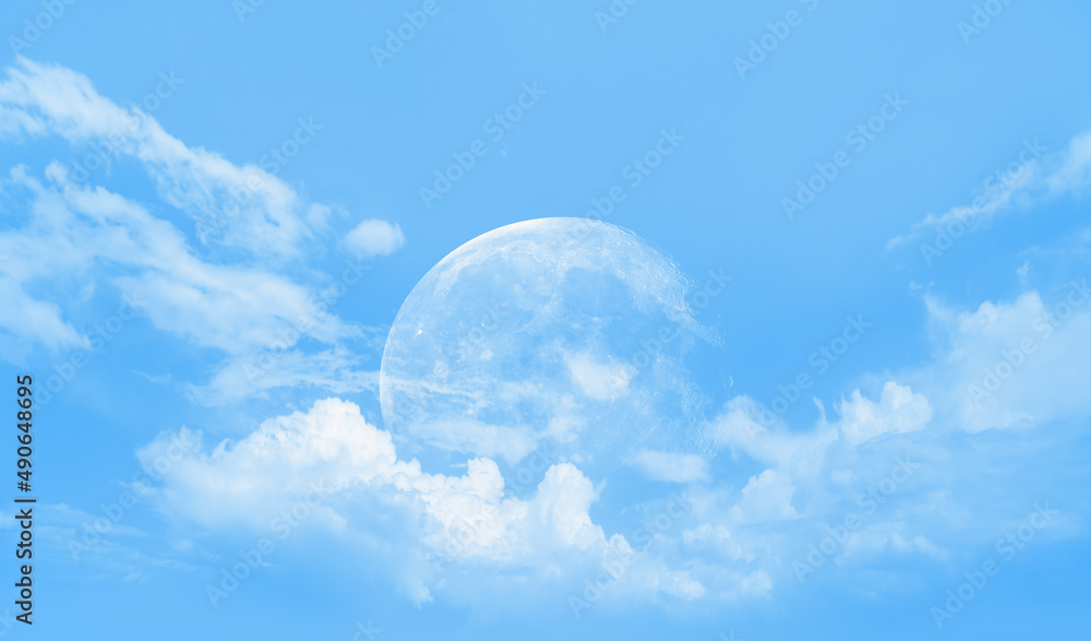 Crescent moon and white clouds. The moon against the blue sky Crescent moon and white clouds. The moon against the blue sky