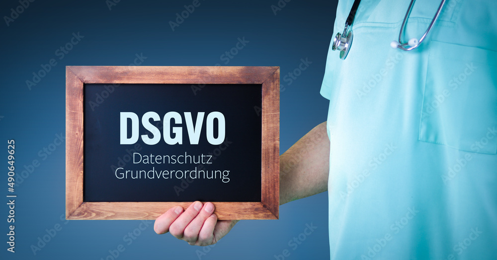 DSGVO (Datenschutz-Grundverordnung). Arzt zeigt Schild/Tafel mit Holz Rahmen. Hintergrund blau DSGVO (Datenschutz-Grundverordnung). Arzt zeigt Schild/Tafel mit Holz Rahmen. Hintergrund blau